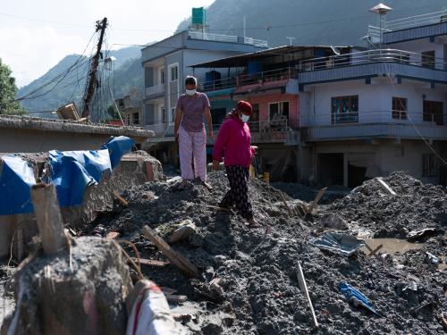 Durga and her daughter survey the damage to their home in Tupche, Nuwakot, Nepal.